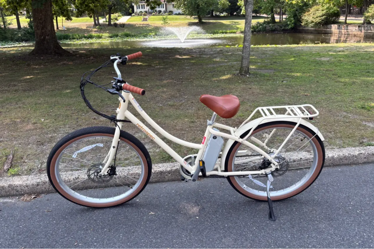 Retrospec Beaumont Rev 3 step-through electric city bike on a paved park road